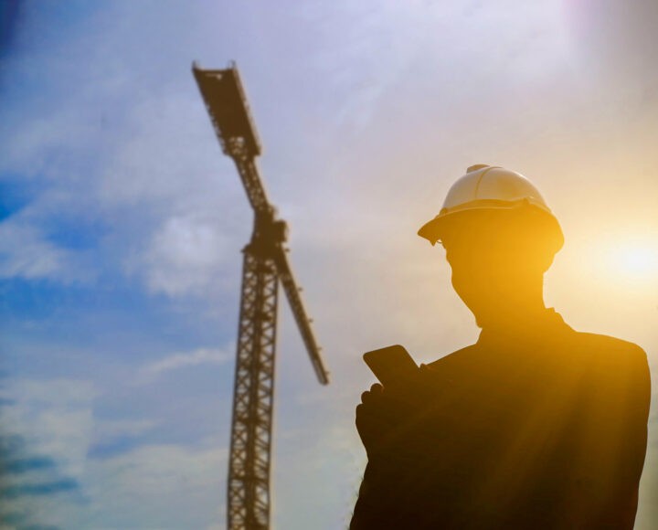 Silhouette of Engineer holding a mobile phone with telecommunica